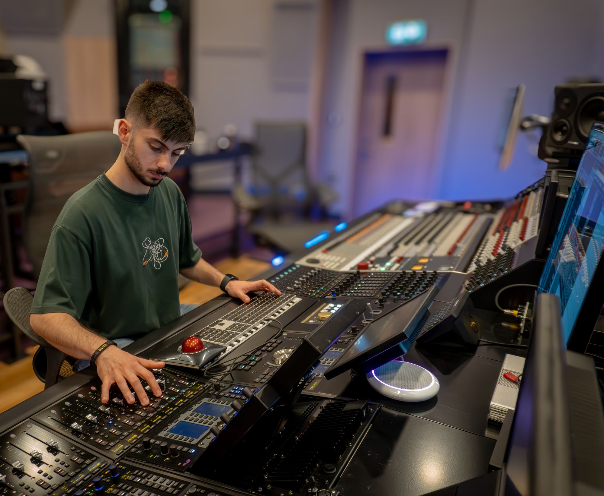 Aram working at a large digital mixing console