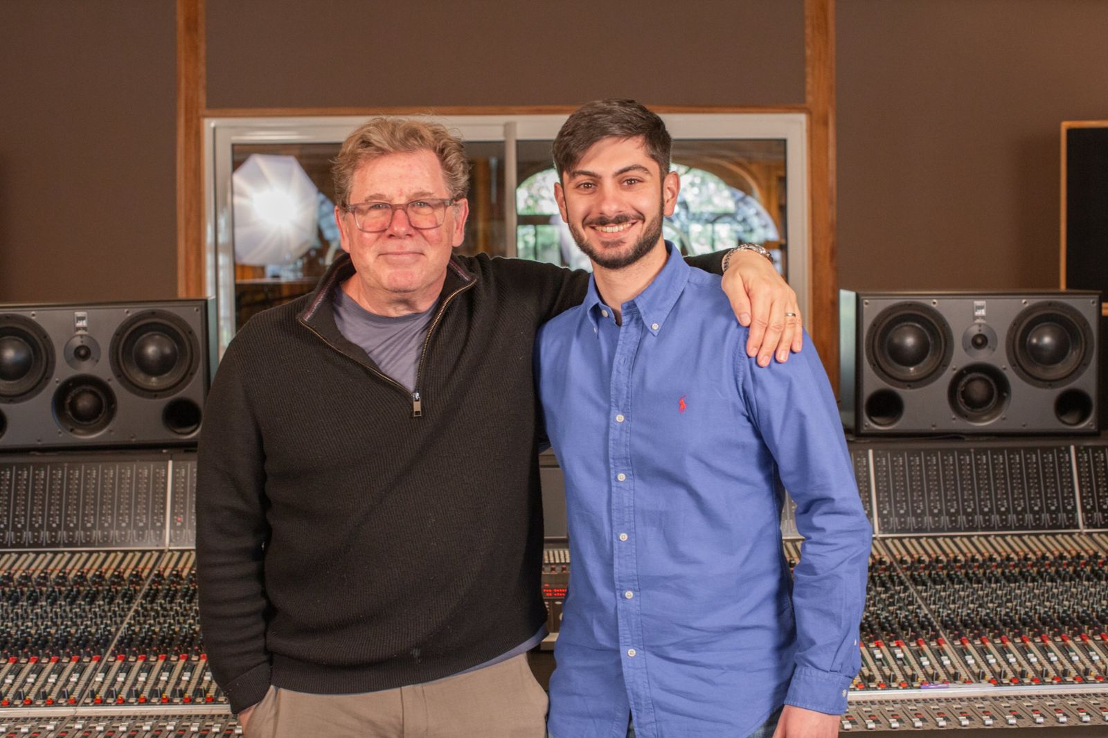 Aram in front of a large analogue console